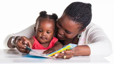 Image of an African American woman reading to her infant child.