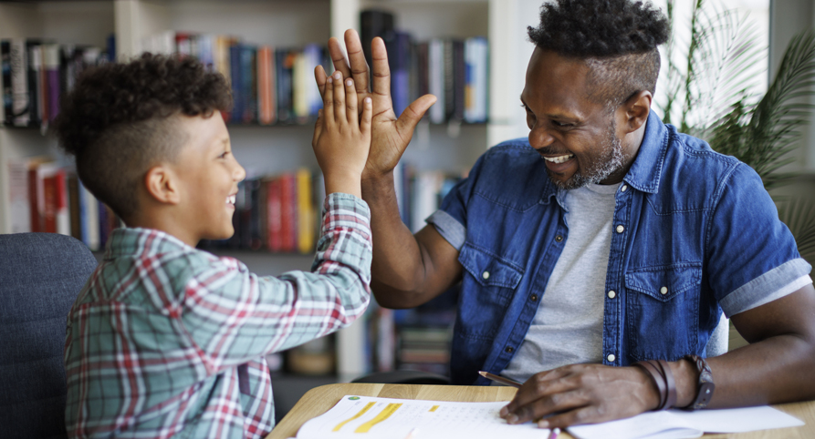 African-American dad helps his son with his homework