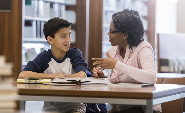 Image of middle school age boy studying with a tutor